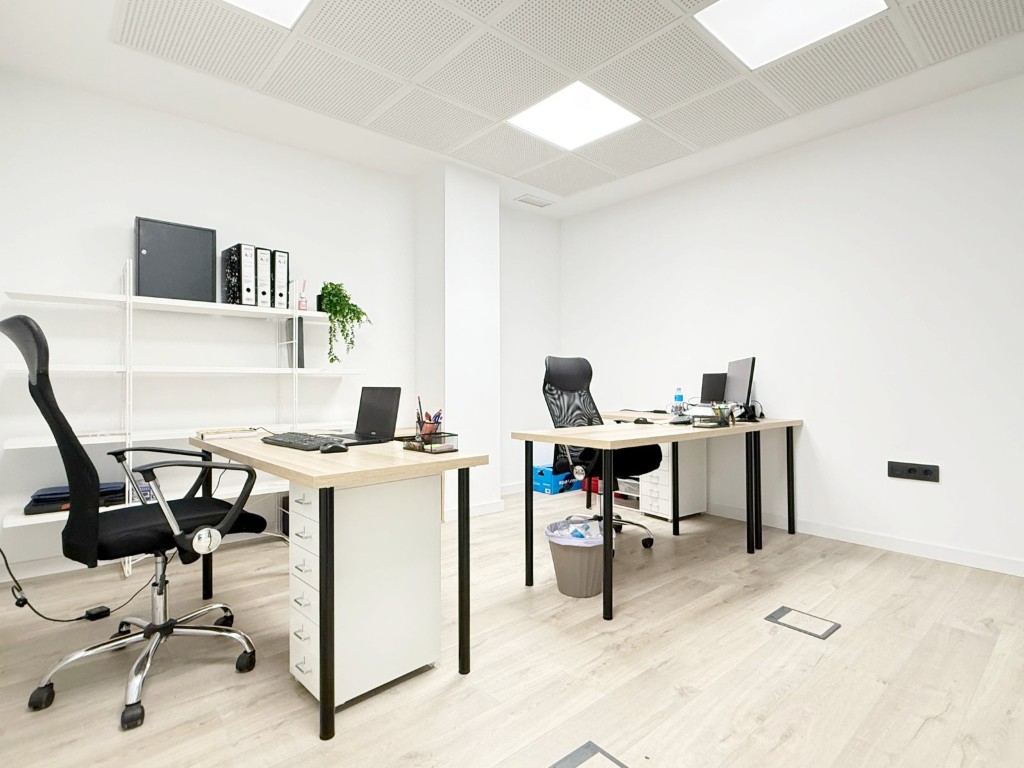 Espacio de trabajo abierto en la oficina AVIRAGO, con zonas equipadas.
